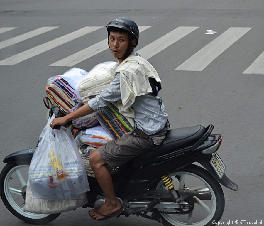Een verkoper op een scooter in de straten van Ho Chi Minh City
