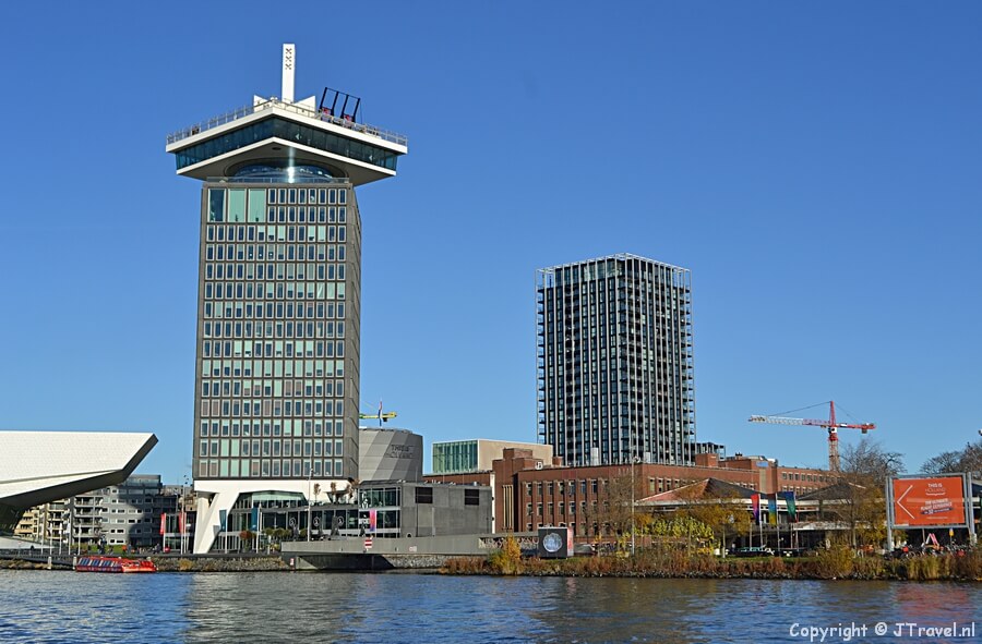 Zicht op Amsterdam Lookout en daarachter THIS IS HOLLAND vanaf de pont over het IJ voor de wandeling door Amsterdam Noord