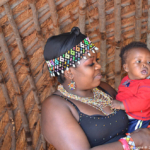 Zuluvrouw met haar kindje in PheZulu Village in de Vallei van 1.000 heuvels<br/>Copyright © JTravel.nl Zuluvrouw met haar kind in PheZulu Village in de Vallei van 1.000 heuvels / Copyright © JTravel.nl