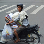 Een overhemdenverkoper op zijn scooter naast de bus in de straten van Ho Chi Minh City op 24-9-2013<br/>Copyright © JTravel.nl Een overhemdenverkoper op zijn scooter naast de bus in de straten van Ho Chi Minh City op 24-9-2013 / Copyright © JTravel.nl