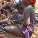 Een vrouw en haar kindje van de Himba stam in Otjikandero<br/>Copyright © JTravel.nl Een vrouw en haar kindje van de Himba stam in Otjikandero / Copyright © JTravel.nl