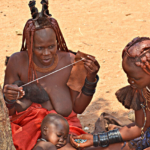 Vrouwen en een kind van de Himba stam in Otjikandero<br/>Copyright © JTravel.nl Vrouwen en een kind van de Himba stam in Otjikandero / Copyright © JTravel.nl