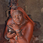 Een vrouw van de Himba stam in haar hut in Otjikandero<br/>Copyright © JTravel.nl Een vrouw van de Himba stam in haar hut in Otjikandero / Copyright © JTravel.nl