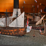 De maquette van de Reede van Texel in het Kaap Skil Museum in Oudeschild<br/>De Reede van Texel, ankerplaats voor zeeschepen, lag voor de zuidoostkust van Texel. Tussen 1500 en 1900 gingen er vele duizenden zeilschepen voor anker. Beschut door het eiland Texel tegen de heersende westenwind was de Reede, dichtbij de Noordzee, een ideaal vertrek- en aankomstpunt voor de scheepvaart. Wie toen over de Reede van Texel keek, zag een woud van masten en een continue bewegen van schepen. De omgeving was gevuld met het geluid van krakend hout en klapperende zeilen en de geur van zilte zeelucht vermengd met die van teer. De maquette van de Reede van Texel geeft een beeld hoe de Reede er in het verleden heeft uitgezien. Ruim honderd schepen die in detail op schaal zijn nagemaakt. Nauwkeurige reconstructies van alle belangrijke scheepstypen, zoals die gebouwd werden in de Gouden Eeuw.<br/>Copyright © JTravel.nl De maquette van de Reede van Texel in het Kaap Skil Museum in Oudeschild / Copyright © JTravel.nl
